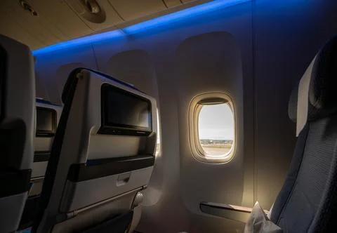 Airplane cabin interior showing empty passenger seats, individual entertain.. Stock Photos