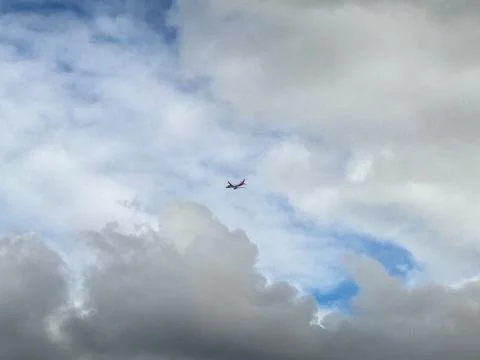 Airplane captured during flight between strongly thick white clouds and blue  Photos