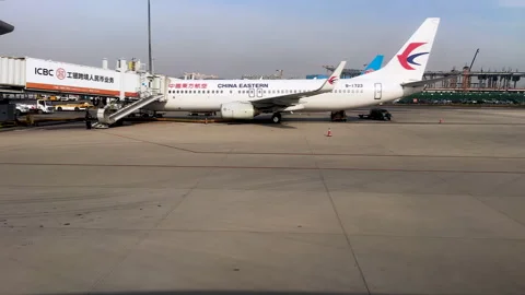 Airplane of China Eastern Airlines connected to passenger air bridge Stock Footage 298204314