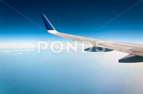 Airplane in clouds above earth Stock Photos
