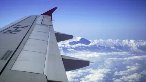 Airplane in the clouds above mountains Stock Footage 146587396