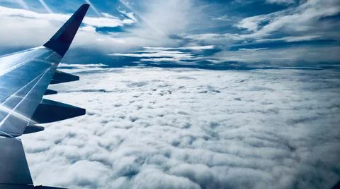 Airplane in the cloudy sky Stock Photos