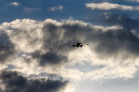Airplane in the cloudy sky. Stock Photos