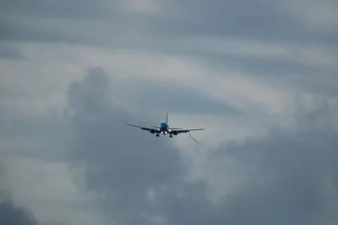 Airplane in the cloudy sky. Stock Photos
