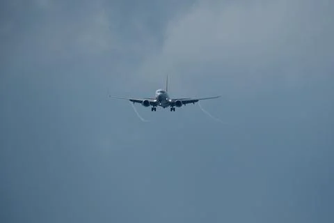 Airplane in the cloudy sky. Stock Photos