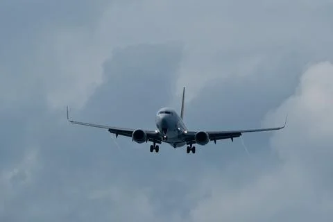 Airplane in the cloudy sky. Stock Photos