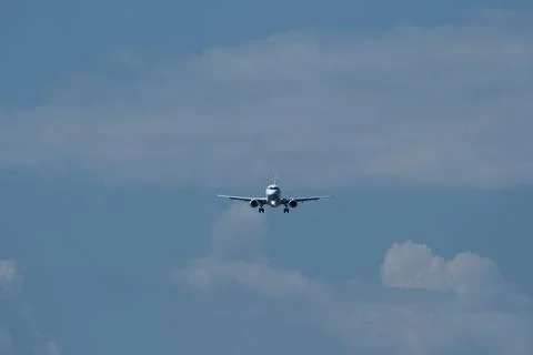 Airplane in the cloudy sky. Stock Photos