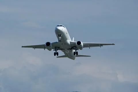 Airplane in the cloudy sky. Stock Photos