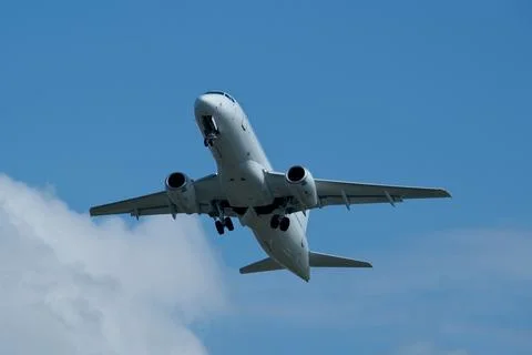 Airplane in the cloudy sky. Stock Photos