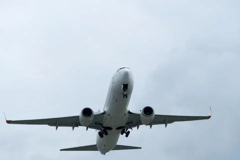 Airplane in the cloudy sky. Stock Photos