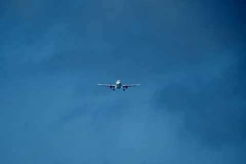 Airplane in the cloudy sky. Stock Photos