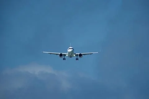 Airplane in the cloudy sky. Stock Photos