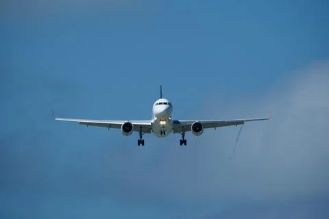 Airplane in the cloudy sky. Stock Photos