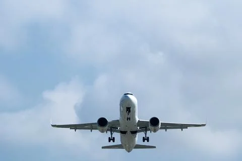 Airplane in the cloudy sky. Stock Photos