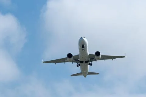 Airplane in the cloudy sky. Stock Photos