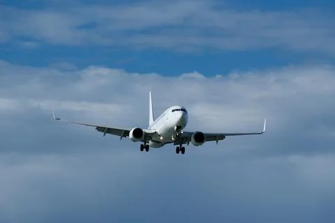 Airplane in the cloudy sky. Stock Photos