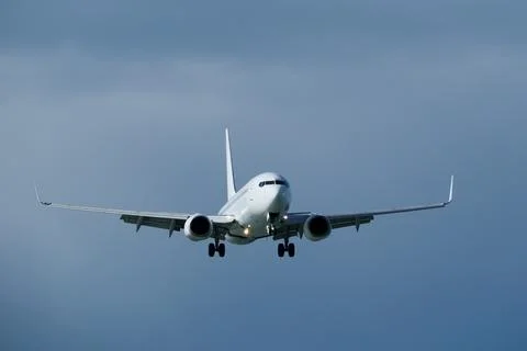 Airplane in the cloudy sky. Stock Photos