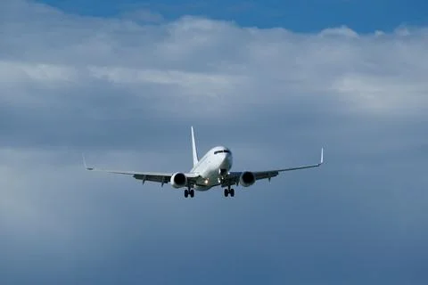 Airplane in the cloudy sky. Stock Photos