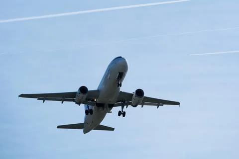 Airplane in the cloudy sky. Stock Photos