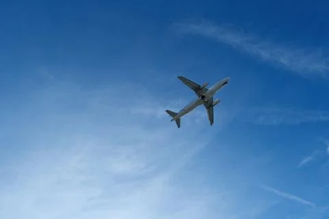 Airplane in the cloudy sky. Stock Photos
