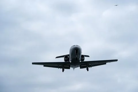 Airplane in the cloudy sky. Private plane in flight, Business jet in the sky. Stock Photos