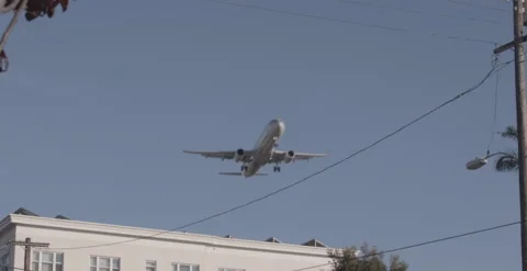 Airplane comes in for landing above neighborhood. Stock Footage