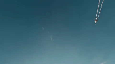 Airplane with contrails flying in front of blue sky Stock Footage 344419850