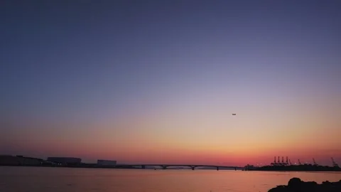 Airplane crossing the magic hour sky over Hakata Bay after sunset Vídeos de archivo 334538307