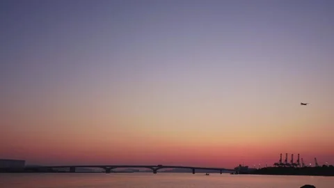 Airplane crossing the magic hour sky over Hakata Bay after sunset Vídeos de archivo 334538326