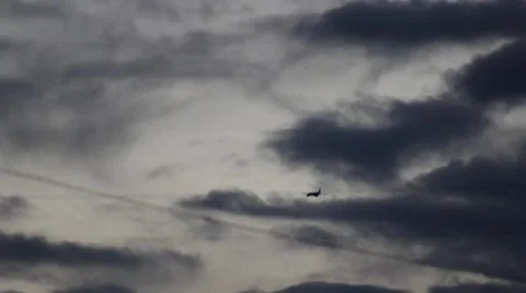 Airplane in the distance with clouds behind Stock Footage 47523429
