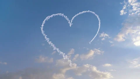 Airplane draws Heart shape on the sky 库存影片 107570236