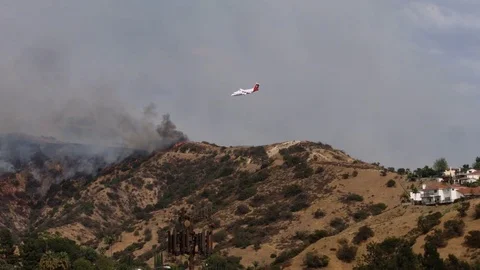 Airplane Drops Fire Retardant on Wildfire Видео 79649710