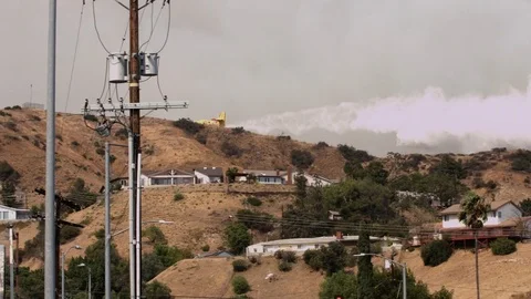 Airplane Drops Water on Wildfire Stock Footage 79649157
