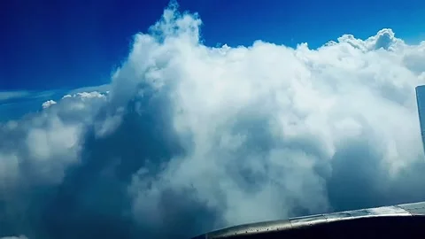 Airplane emerging from clouds into clear sky Stock Footage 333454263