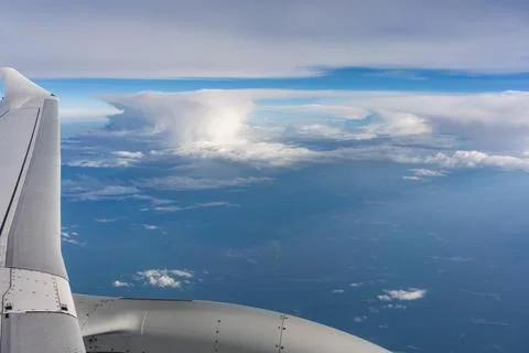 Airplane engine and wing frame towering clouds during passenger flight Stock Photos