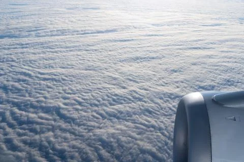 Airplane engine and wing view above clouds from window seat travel aviation conc Stock-Fotos