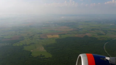 Airplane engine flying over green fields aerial view Stock Footage 345682009