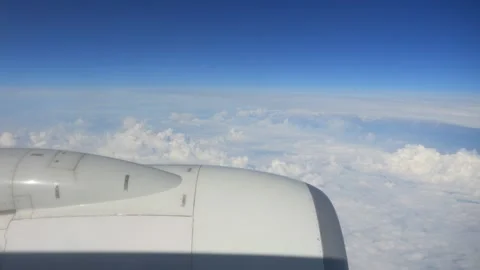 Airplane engine over a backdrop of clouds in a clear blue sky in 4K slow mo.. Stock Footage 294895667