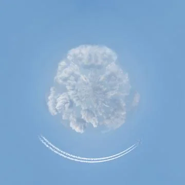 Airplane flies around white clouds, jet trail in the shape of smile Stock Photos