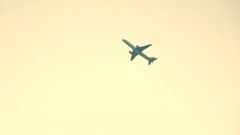 Airplane flies into clouds on gold sky Stock Footage 204997922