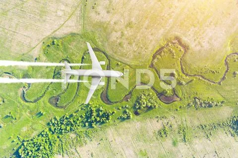 Airplane flies gaining height against the background of the aerial landscape Stock Photos