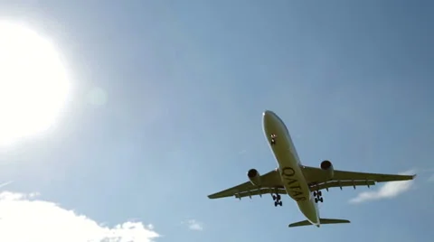 Airplane flies low past the sun to land Stock Footage 31875179