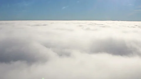 Airplane flight above clouds, side window of plane. Blue sky above white clouds. Stock Footage 58130679