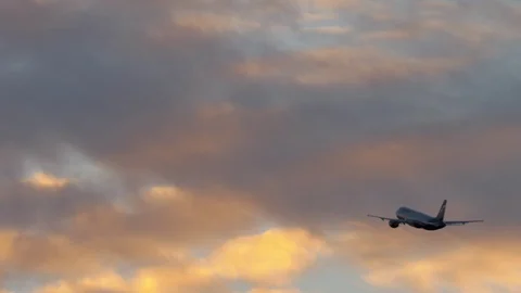 Airplane flight in cloudy evening sky Stock Footage