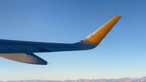 Airplane flight. Illuminator view on wing of airplane. Mountains on horizon Stock Footage 251325327