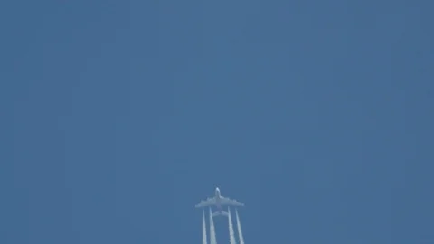 Airplane in flight, making a white stripe in the blue sky, called a contrail Stock Footage 88977369