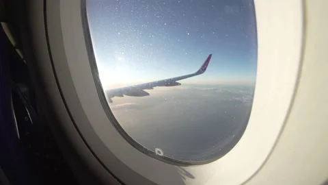 Airplane flight. Window View Above the Clouds at Sunset. Aerial view from Stock Footage 134383814