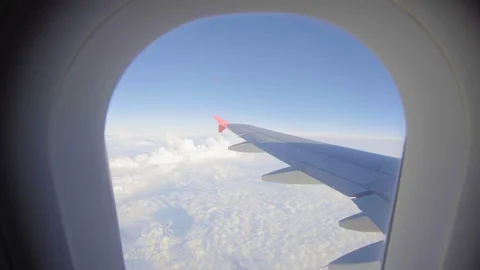 Airplane flight. Wing of an airplane flying above the clouds. View from the Stock Footage 107635374