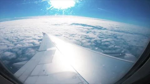 Airplane flight. Wing of an airplane flying above the clouds with sunset sky. Stock Footage