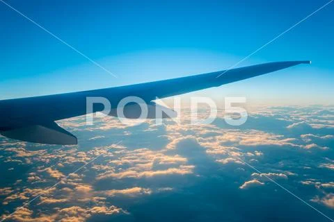 The airplane fly in the sky on the background of beautiful clouds Stock Photos